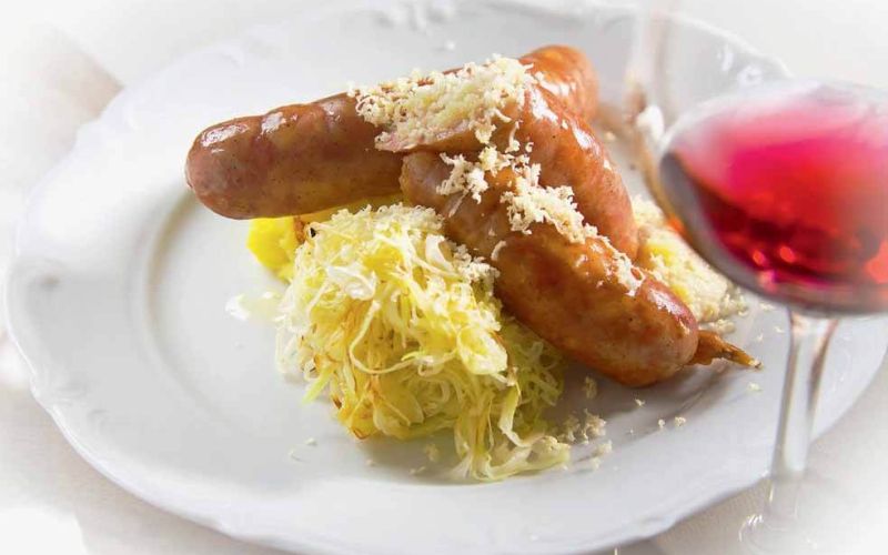 kranjska klobasa s prazenim krompirjem hrenom in zeljem