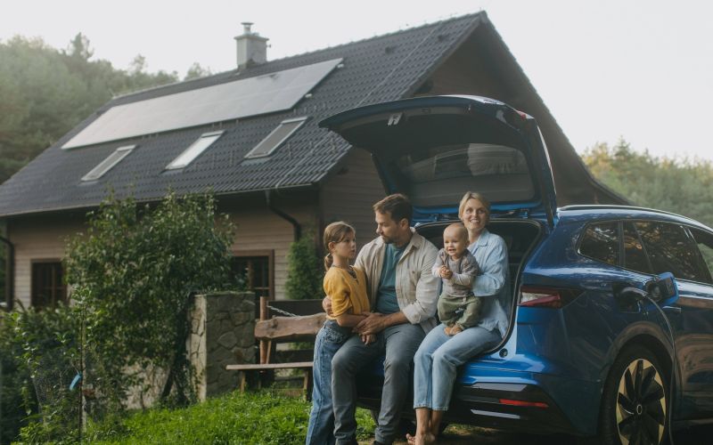 Družina pred hišo, solarni paneli, sončna elektrarna, električni avto