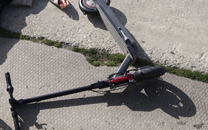 full-shot-man-electric-scooter-laying-ground.jpg