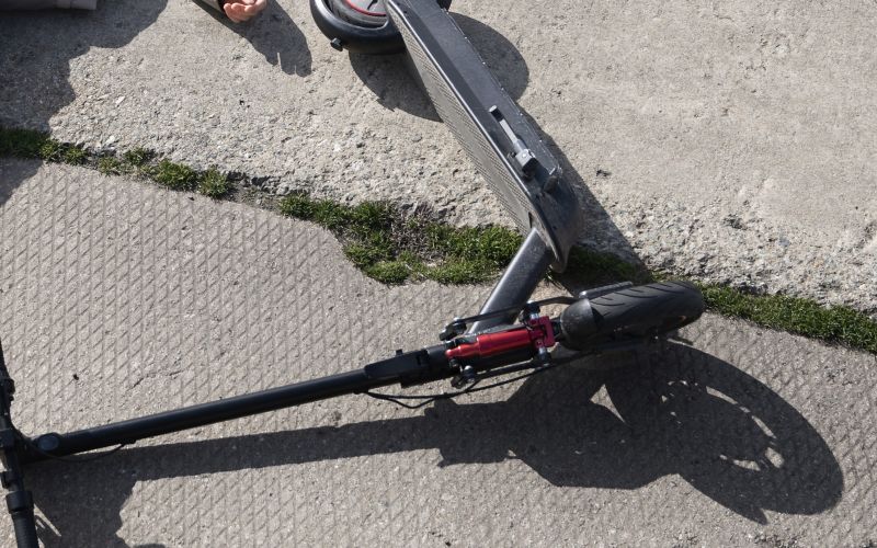 full-shot-man-electric-scooter-laying-ground.jpg