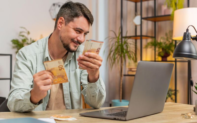 vesel moški prešteva denar