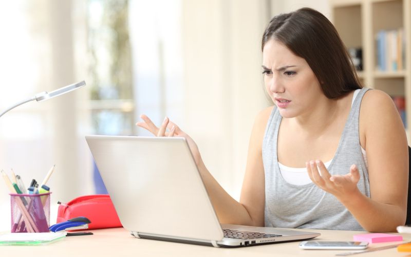 ženska pri prenosniku, ki ne deluje