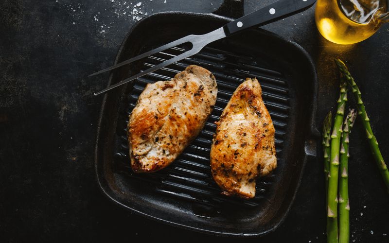 fried-appetizing-tasty-chicken-breast-served-skillet-with-asparagus-dark-background.jpg