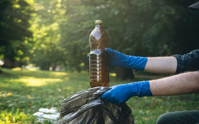 closeup-plastic-bottle-male-hand-cleaning-up-nature.jpg