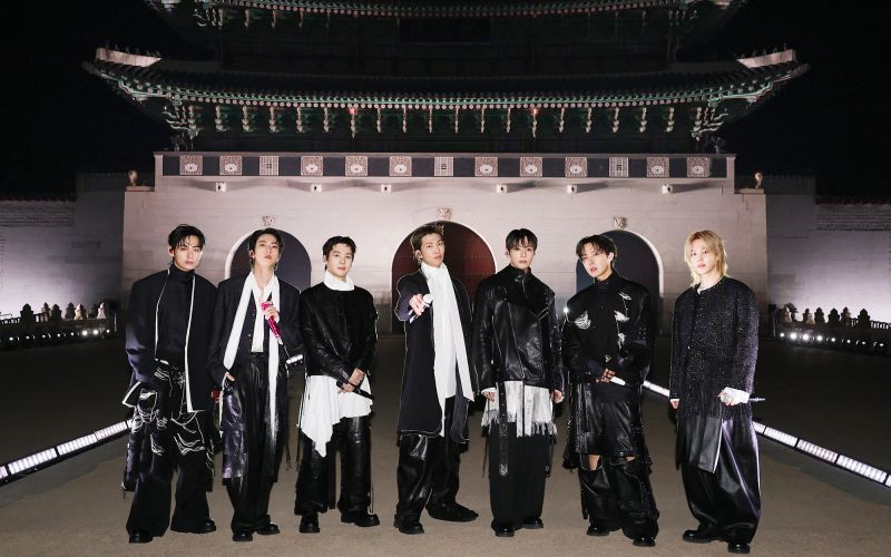 Vseh sedem fantov (od leve proti desni: V, Jin, Suga, RM, Jung Kook, J-Hope in Jimin) zbranih pred ikonično kuliso na seulskem trgu Gwanghwamun marca 2026.