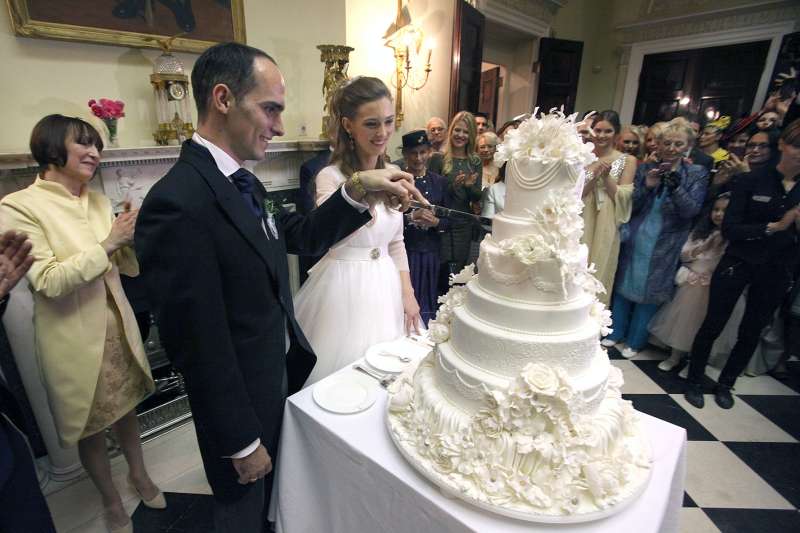 Kot povsem običajni mladoporočenci sta tudi princ in princesa sama zarezala v razkošno poročno torto.
