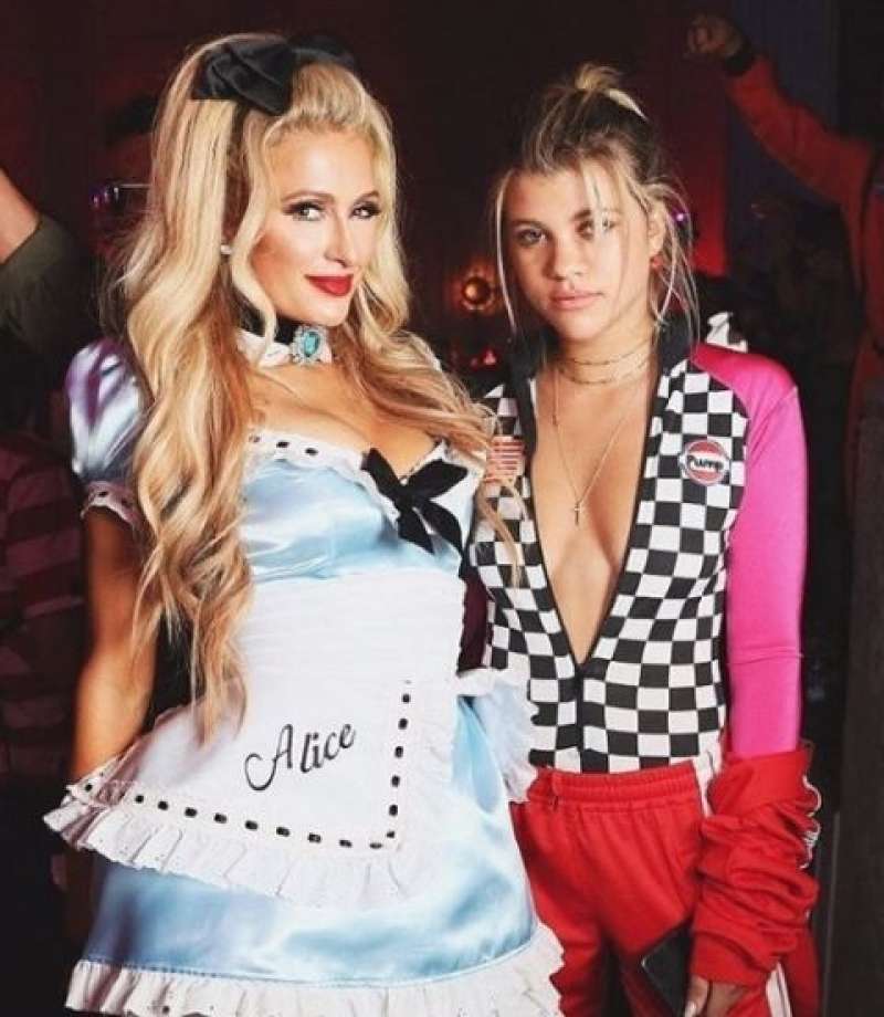 Paris Hilton in Sofia Richie kot Alica v čudežni deželi in voznik rejlija.
